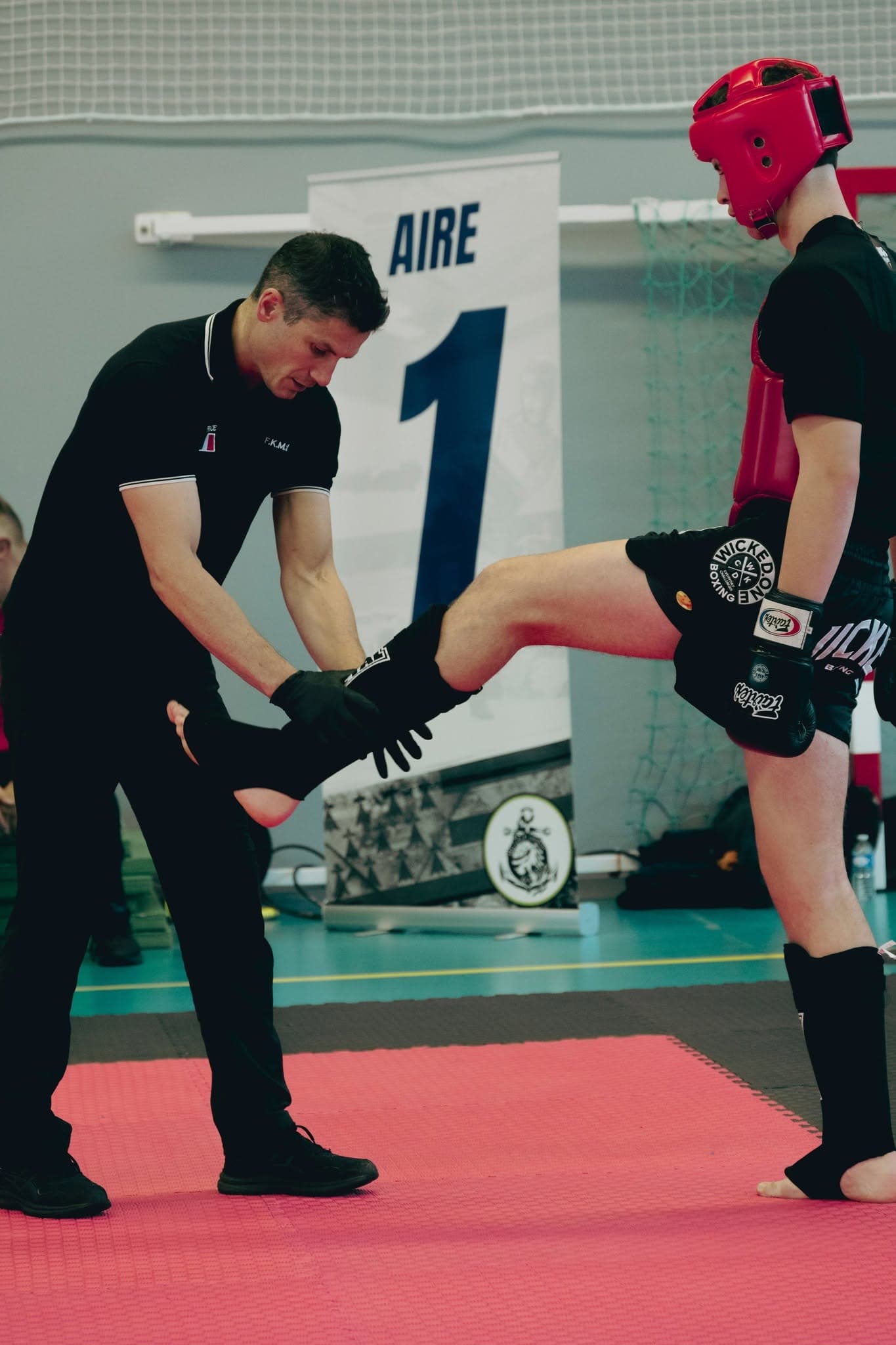 L'arbitre central vérifie la conformité des équipements de protection avant un combat Light